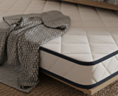 Détail du bord du matelas Essential Oli – coutil 100% polyester respirant et doux avec liseré marine